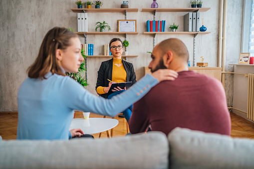 Couple sitting on a couch supporting each other during a couples counseling session with a therapist in San Francisco