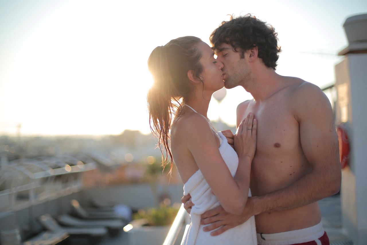 Romantic couple kissing outdoors at sunset to build emotional and physical intimacy