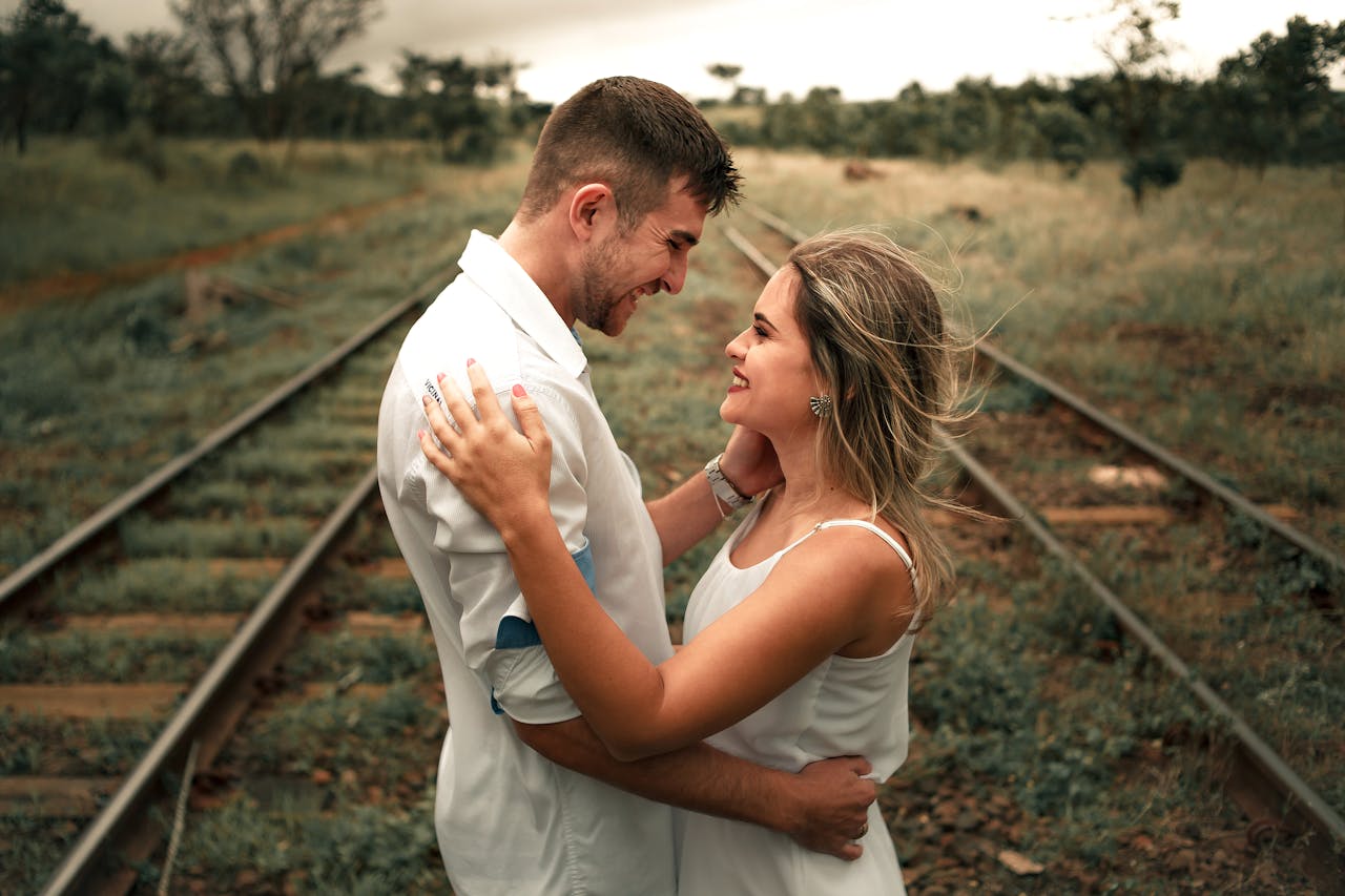 A happy couple embracing and smiling together outdoors, symbolizing trust and open communication to overcome money issues in marriage.