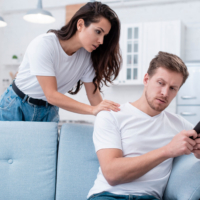 A concerned woman placing her hand on the shoulder of her upset partner during a conversation.