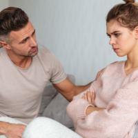 An upset couple looking tense and distant during a serious argument
