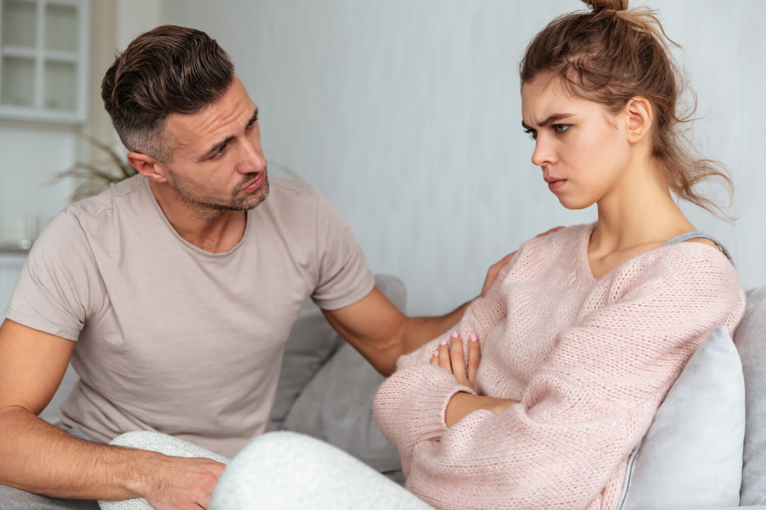 An upset couple looking tense and distant during a serious argument